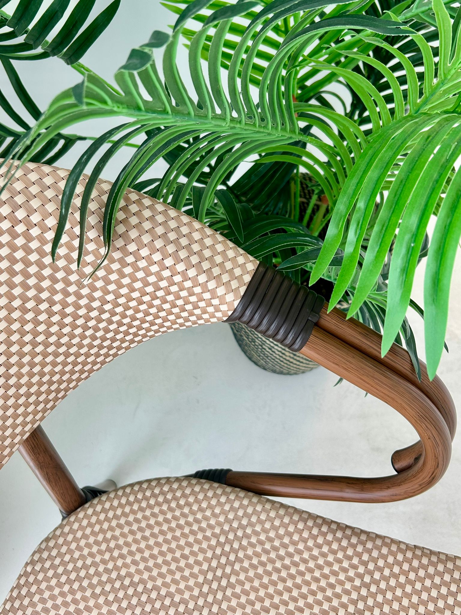 Close-up van rug en armleuningen van de Nice stoel. Luxe gevlochten kunststof in beige bruin, onderhoudsvriendelijk en stijlvol. Ideaal als horecameubilair outlet voor café- en restaurantterrassen.
