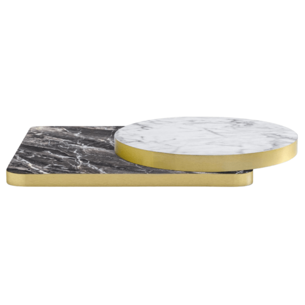 Detailbeeld van een gestapeld rond en vierkant laminaat tafelblad in respectievelijk wit en zwart marmerdecor. Beide afgewerkt met een vlakke ABS rand in messingkleur. Deze horeca tafel bladen bieden veelzijdigheid in vorm en uitstraling en passen bij elk concept van horecameubilair.