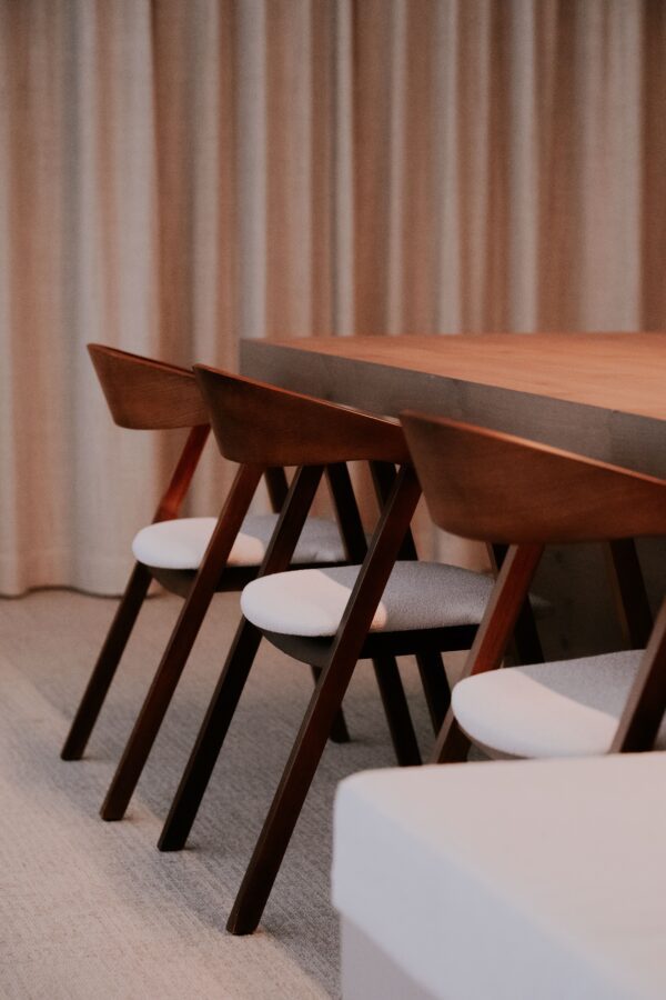 Ruime kantoorruimte met maatwerkbanken in zachte beige stof en houten tafels, ontworpen voor akoestisch comfort.