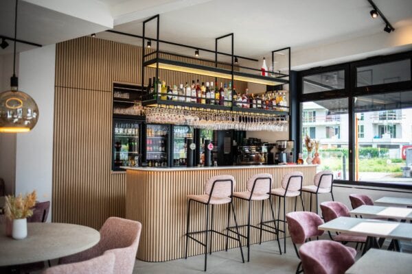 Ruim en licht interieur van BarMatz in Erembodegem met op maat gemaakte horeca zitbanken, barkrukken en ronde tafels in een warme, zachte sfeer.