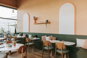 Een sfeervolle horecazaak ingericht met stevige HPL-horecatafels en houten horeca stoelen met bekleding – een perfecte combinatie van comfort en design.