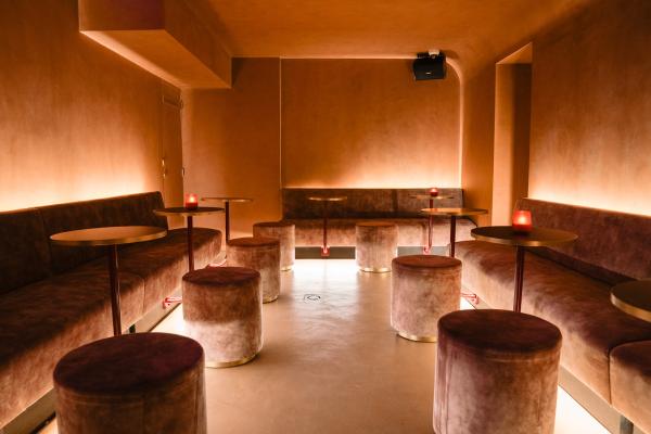 Volledige zithoek met op maat gemaakte horeca zitbanken, ronde Fenix tafelbladen en gestoffeerde poefs. Warme, sfeervolle horeca inrichting met ledverlichting onder de banken.