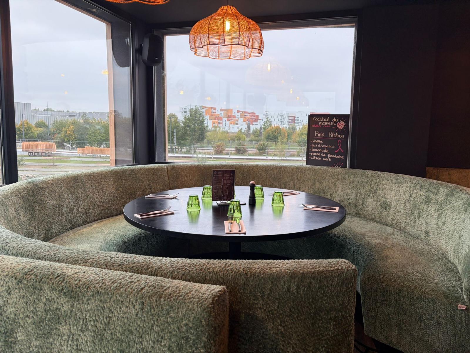 Horeca meubilair met kwaliteitsvolle op maat gemaakte horeca meubels voor Quai 16 in Roubaix (5) Halfronde opstelling met een grote, ronde horeca tafel en volledig op maat gemaakte, groene zitbank. De bekleding voelt zacht en uitnodigend, ideaal voor een gezellige groepsdiner in een moderne inrichting brasserie of restaurant.